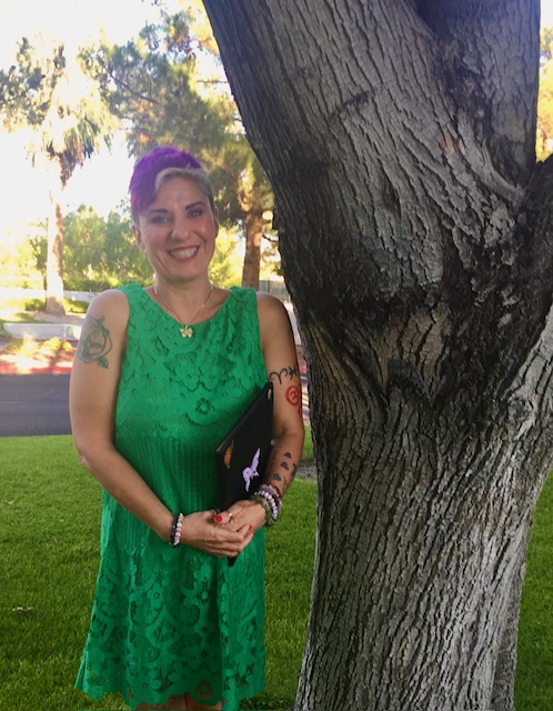Butterfly Love in a green dress standing beside a tree